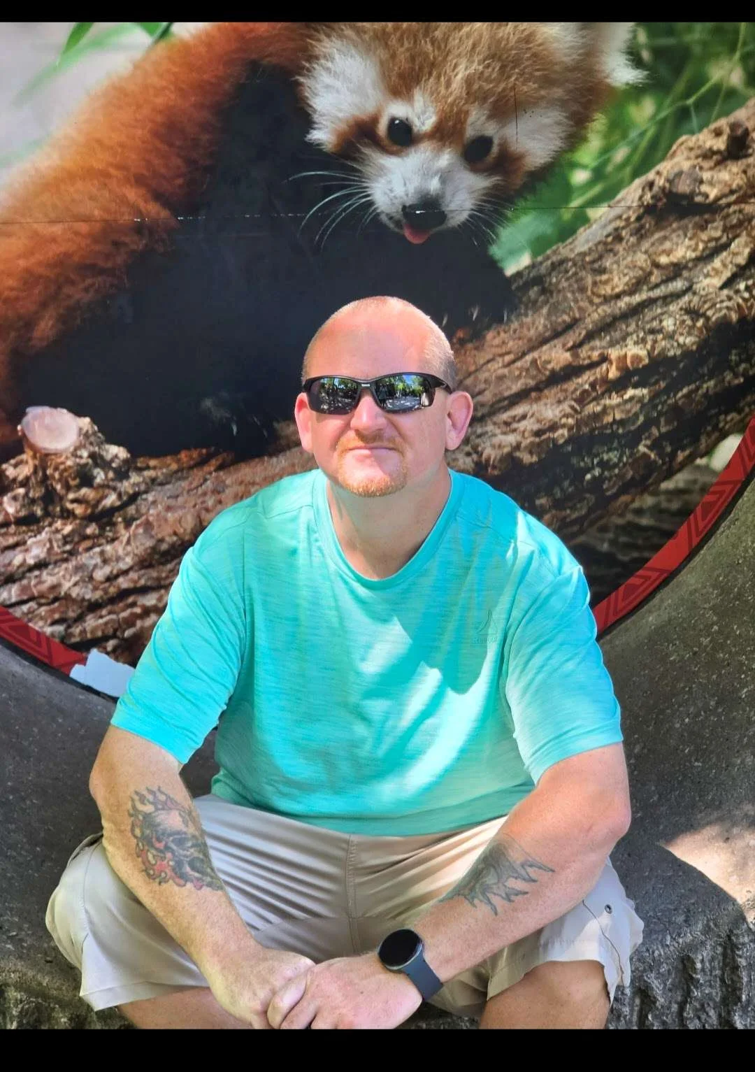 Scott Downum in front of a red panda habitat display
